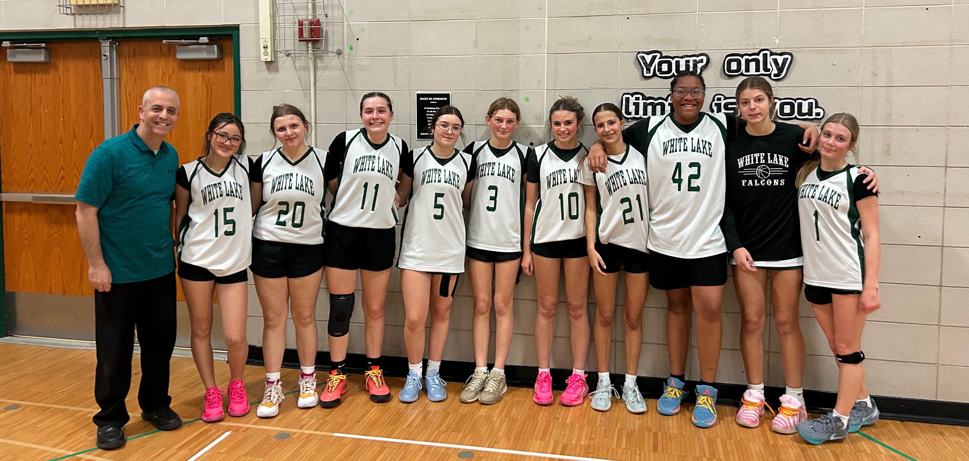 girls basketball team posing for photo in uniforms