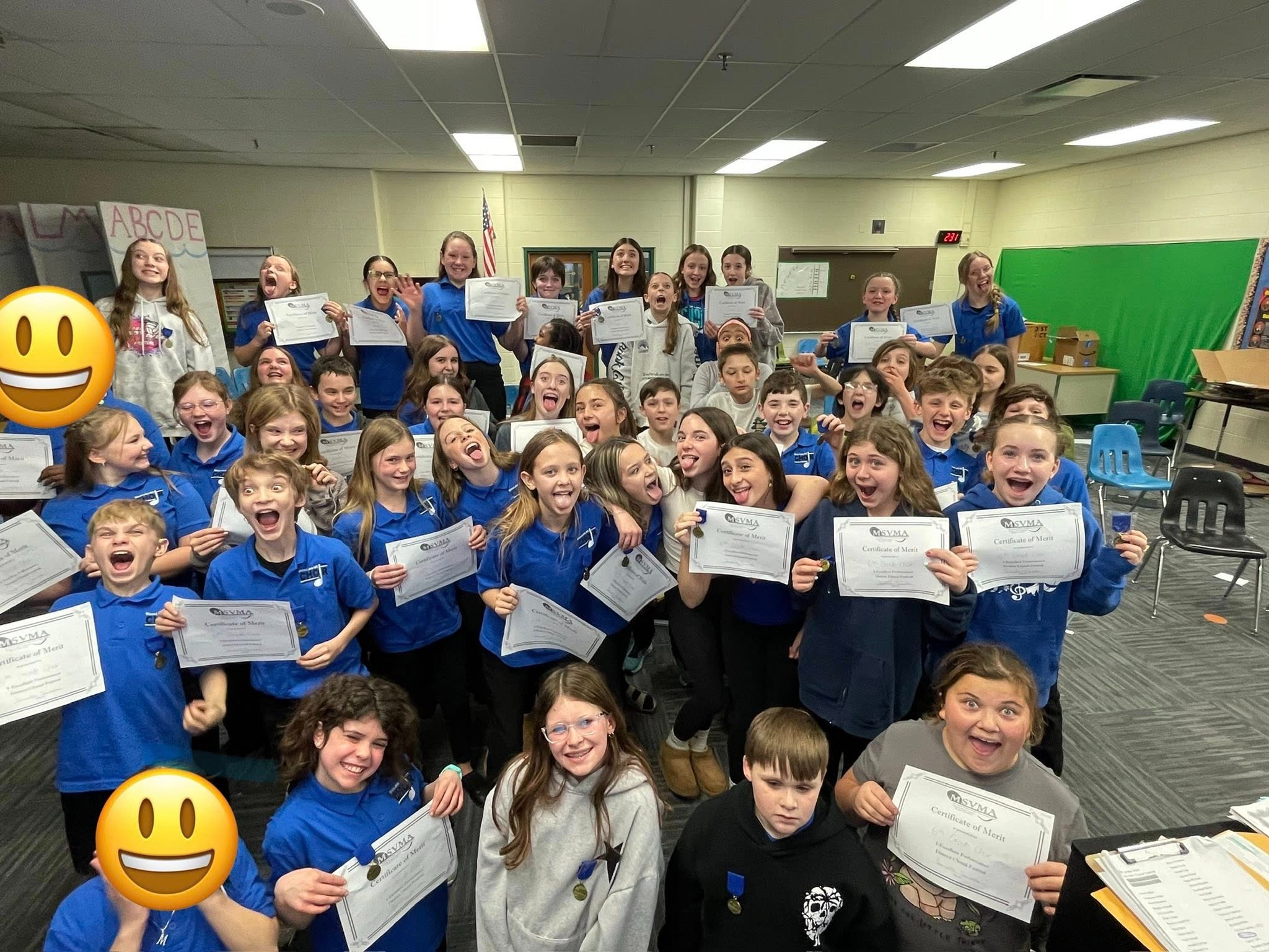 students holding certificates posing for photo in class
