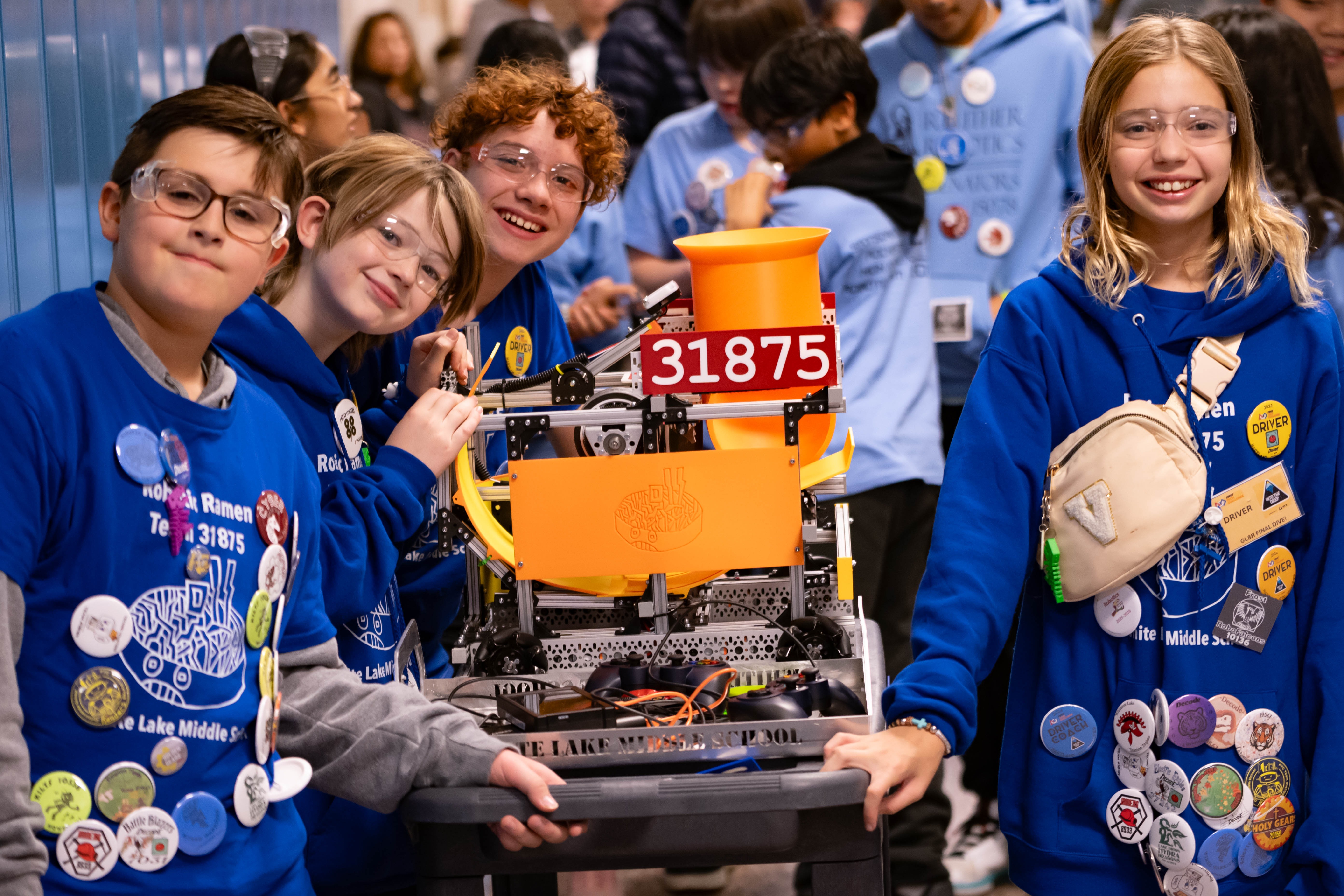 WLMS Robotics team members posing with one of their robots presented at competition