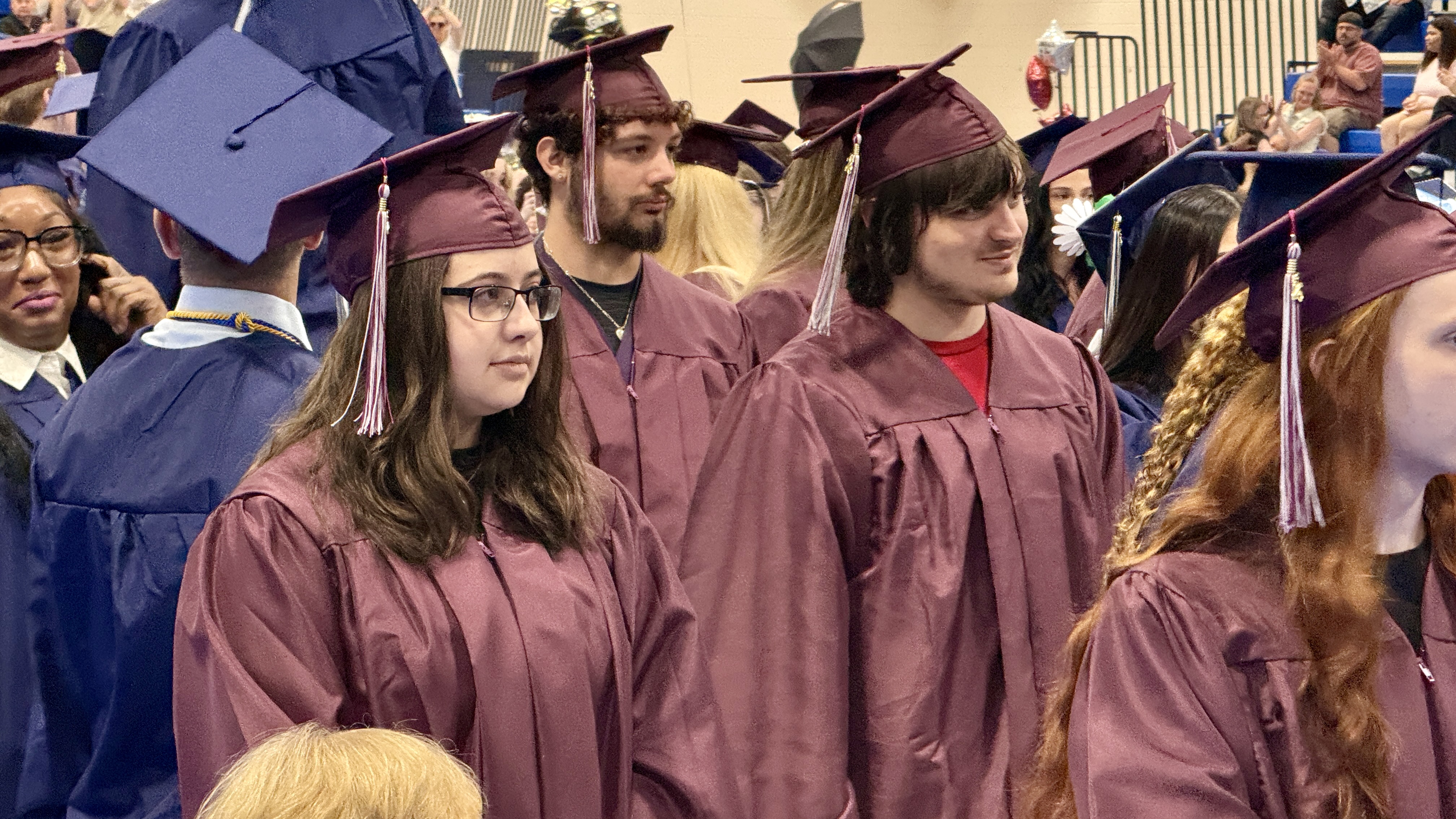 Photo of graduates in cap and gown at ceremony