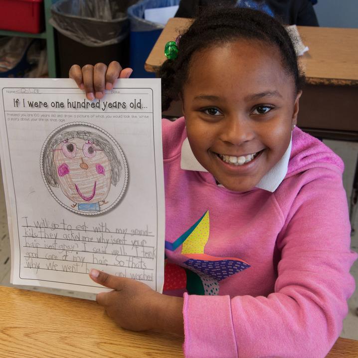 Kids holding up her drawing