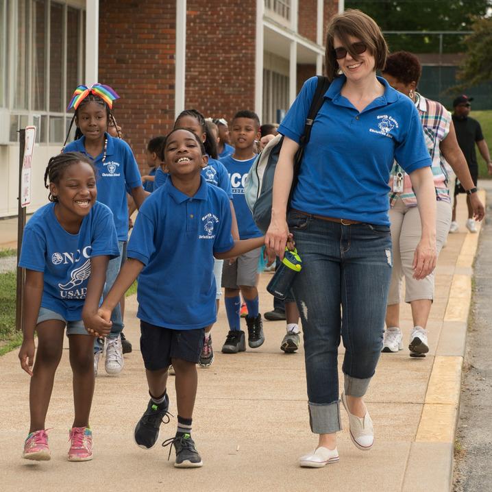 Elementary teacher and leading her students out the school