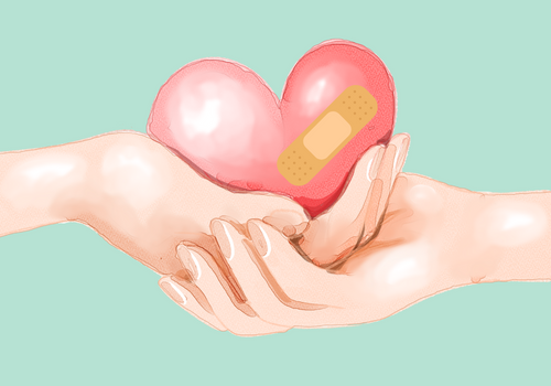hands holding heart with bandaid on it