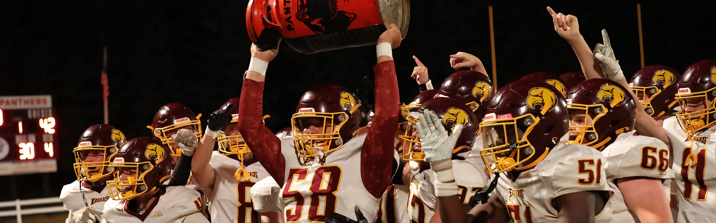 football team holds up the milk can after their win