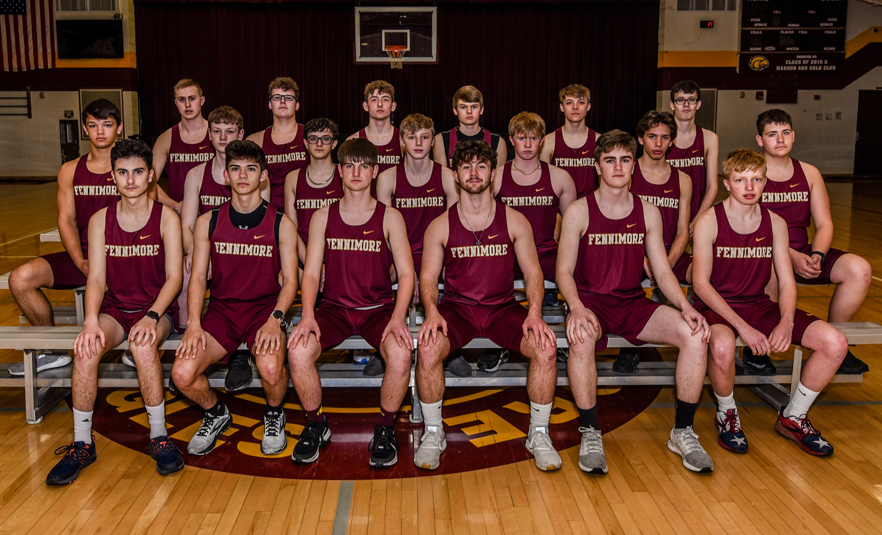 2022 Boys Track Team sits on bleaches in gym