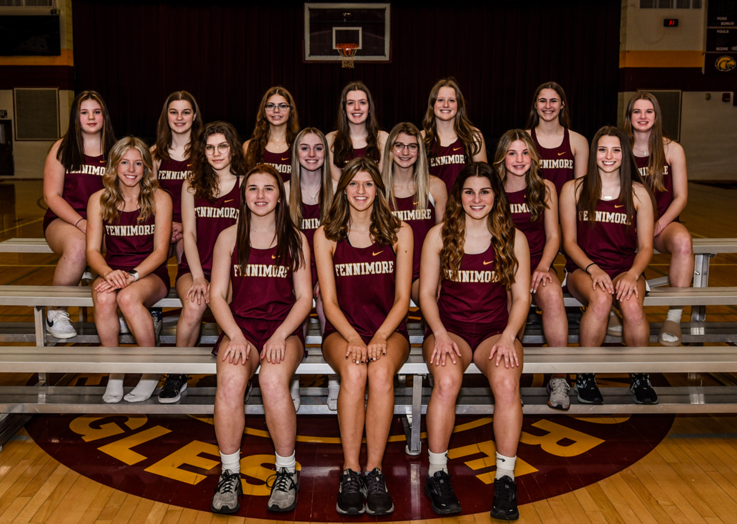 2022 Girls Track Team sits on bleaches in gym