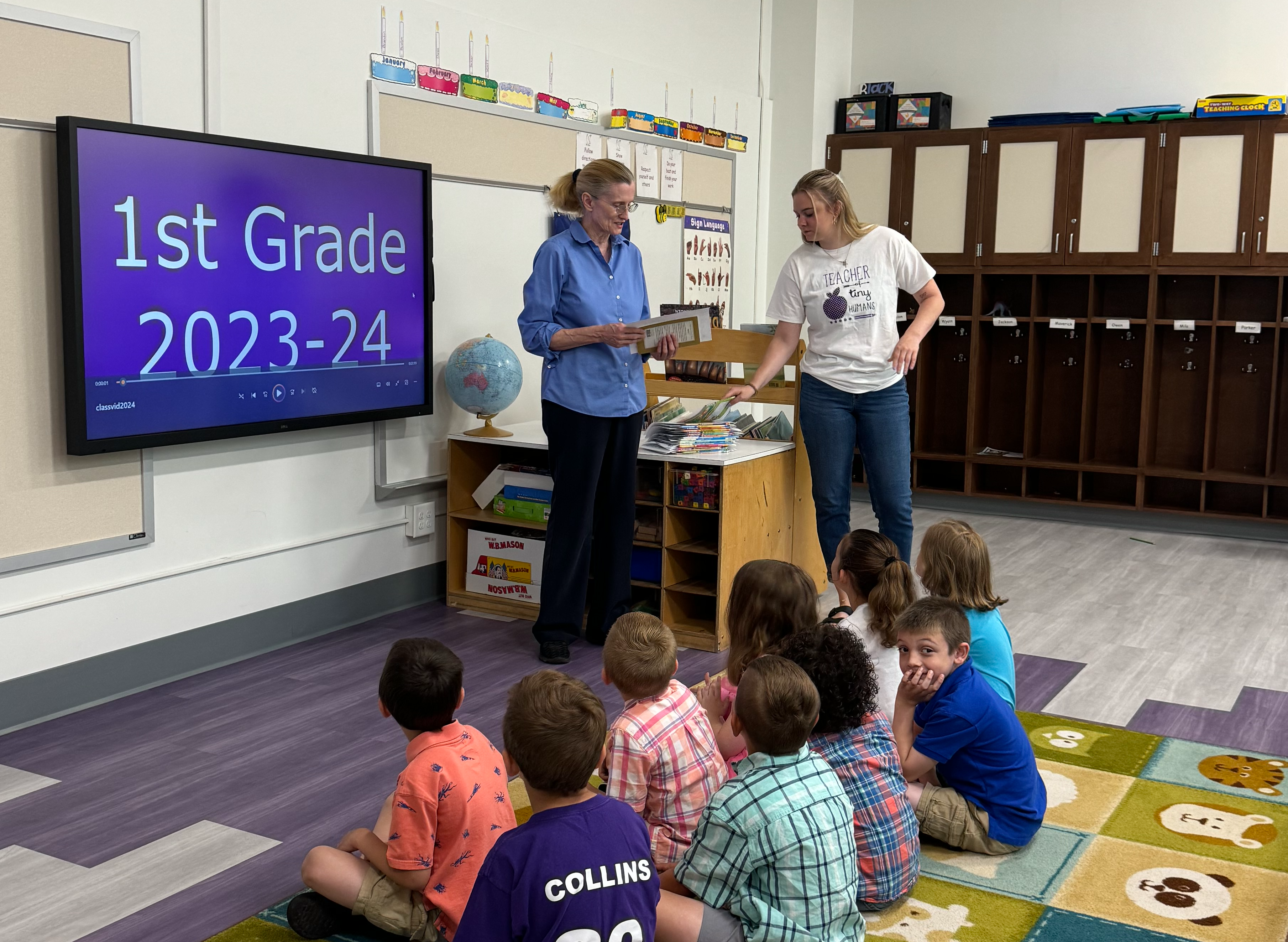 two teachers standing while kids sit in classroom