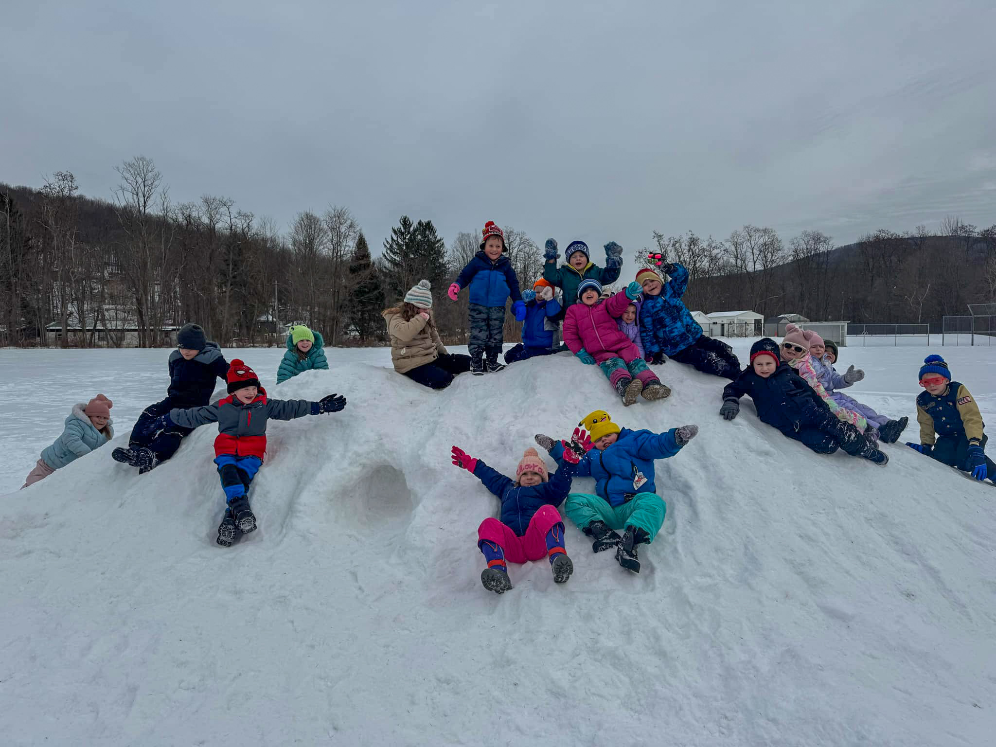 students outside playing on snow hill