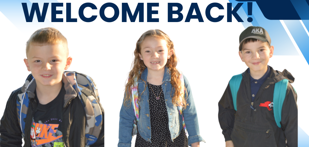 Three elementary students with backpacks smile for the camera on first day of school