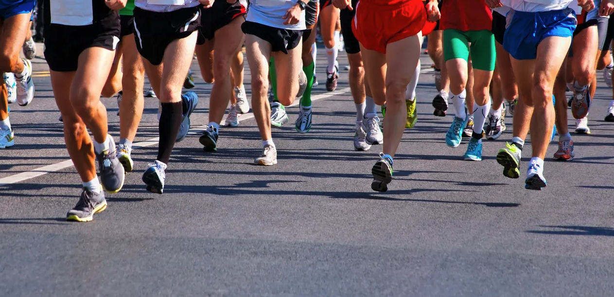 Many runners running in a race only showing the waist down