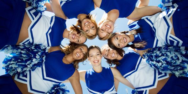 Cheerleaders  leaning forward with the heads together