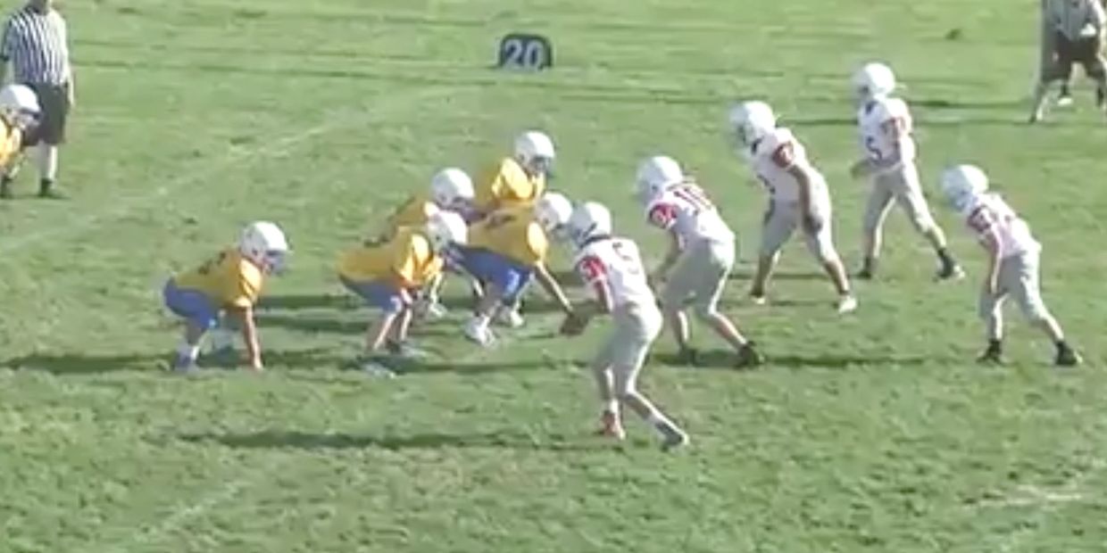 Two junior high boys football teams playing a game