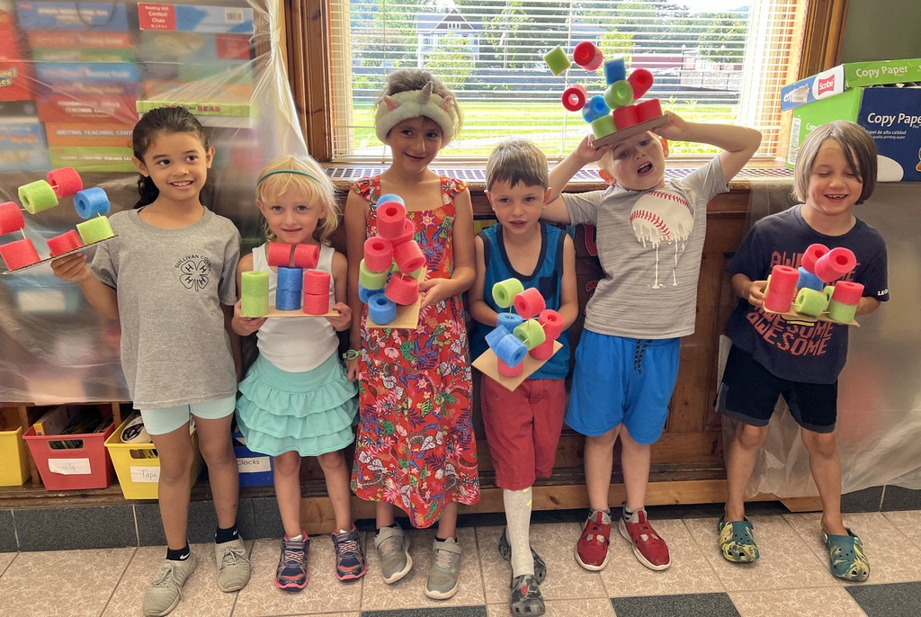 Kids smiling in a group photo in class