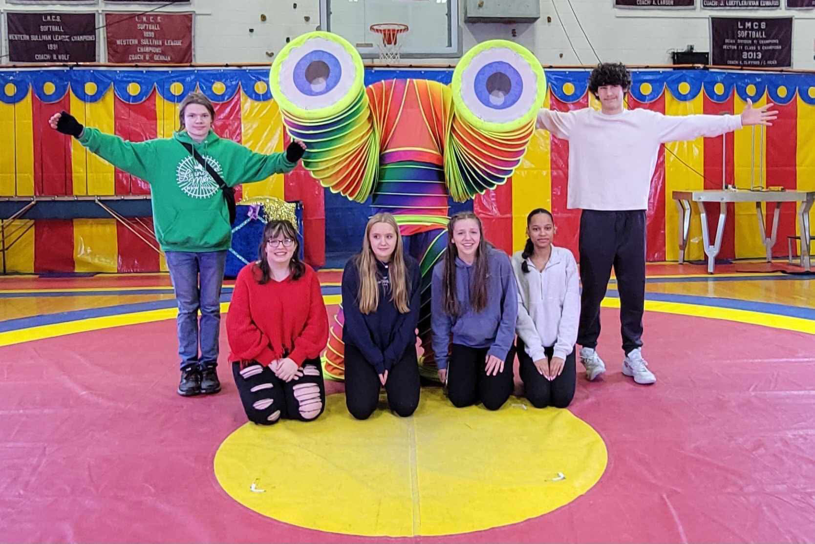 Students pose with a colorful character