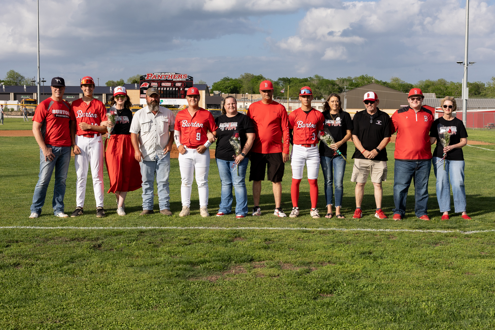 group of baseball players standing with their parents