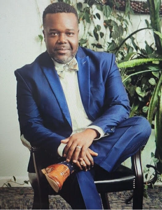 Photo of black male, with blue suit and bowtie