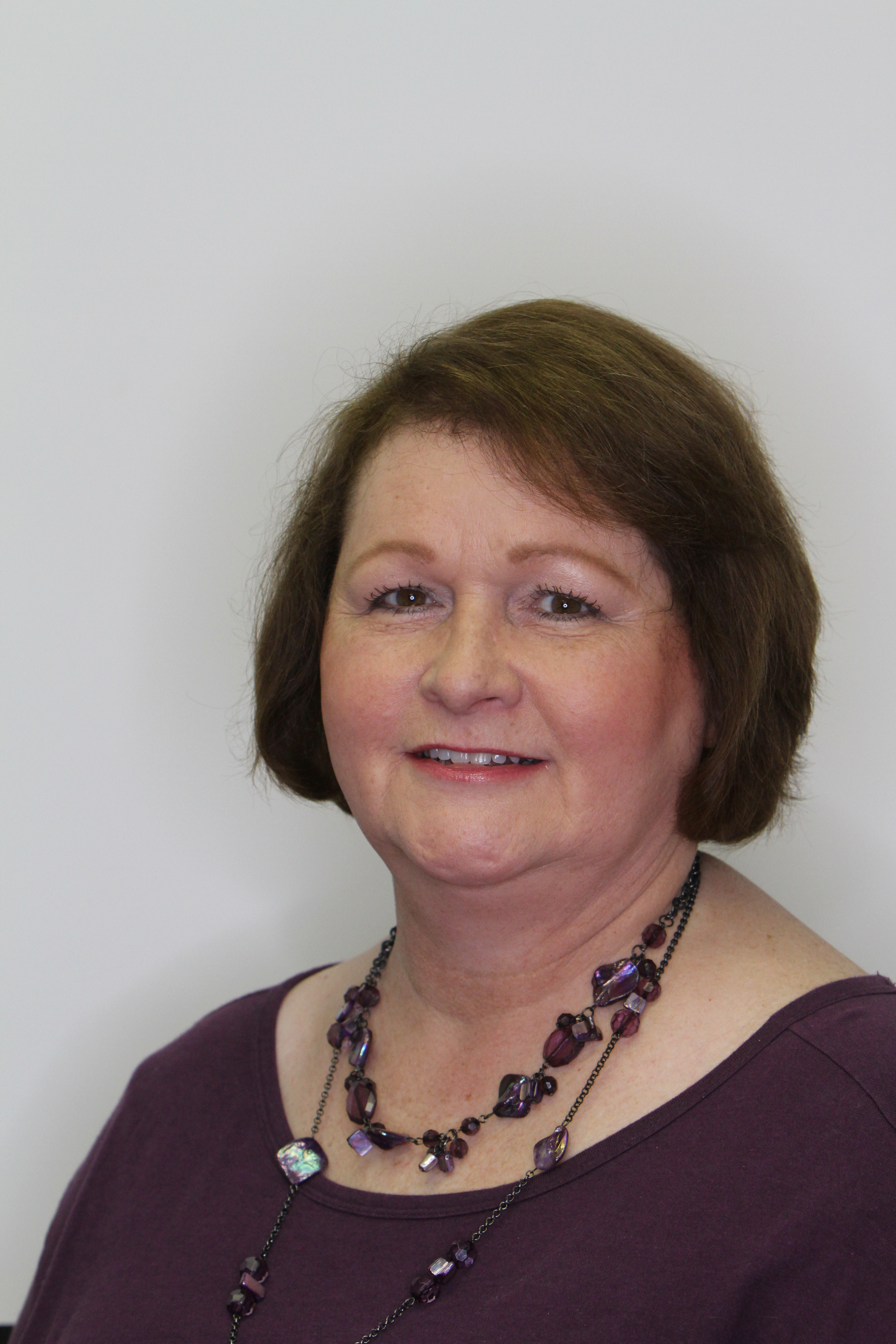 Photo of white female with short dark hair, big necklace