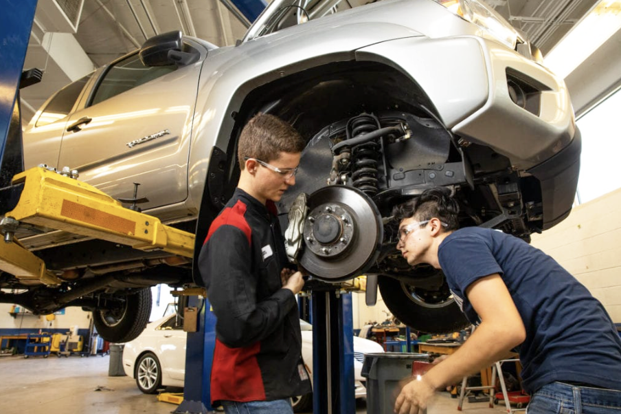 Two CTE Students working on a car