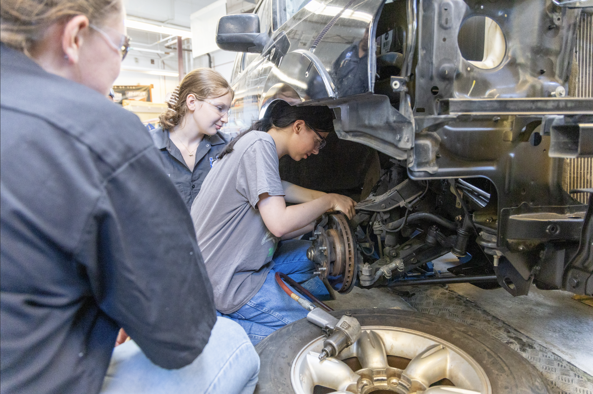 CTE students working on the wheel well of a car