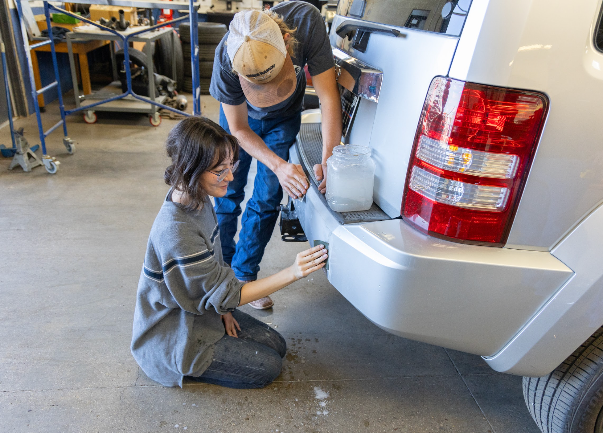 Students working on the exterior of a car