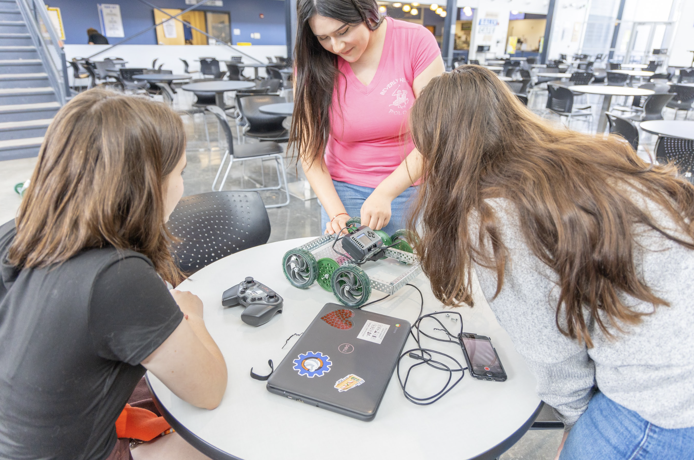 Three CTE Students working on their robotic car