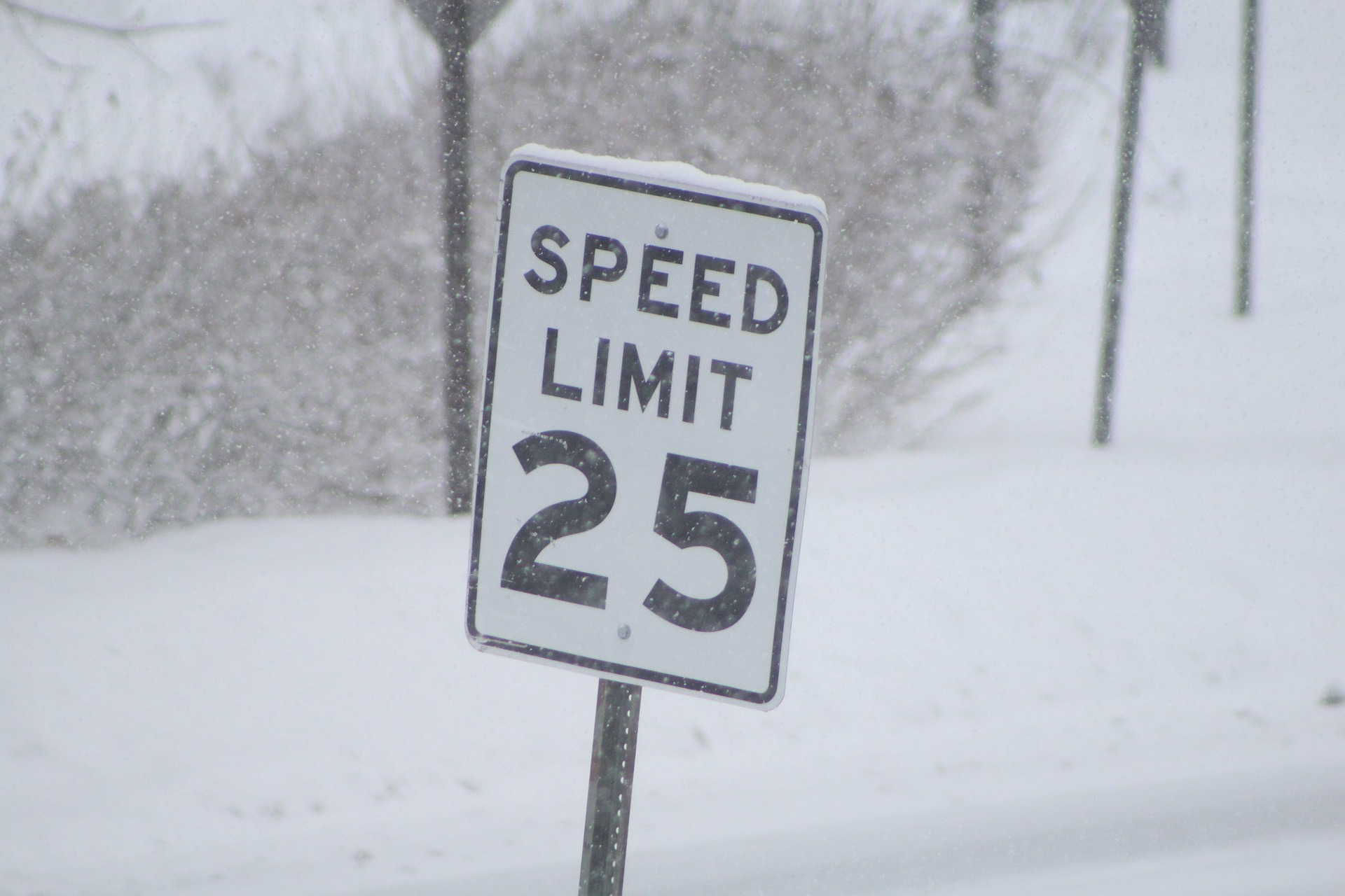 Speed limit sign surrounded by snow