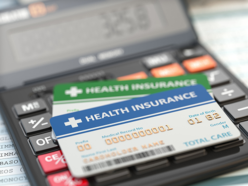 medical insurance cards on a calculator