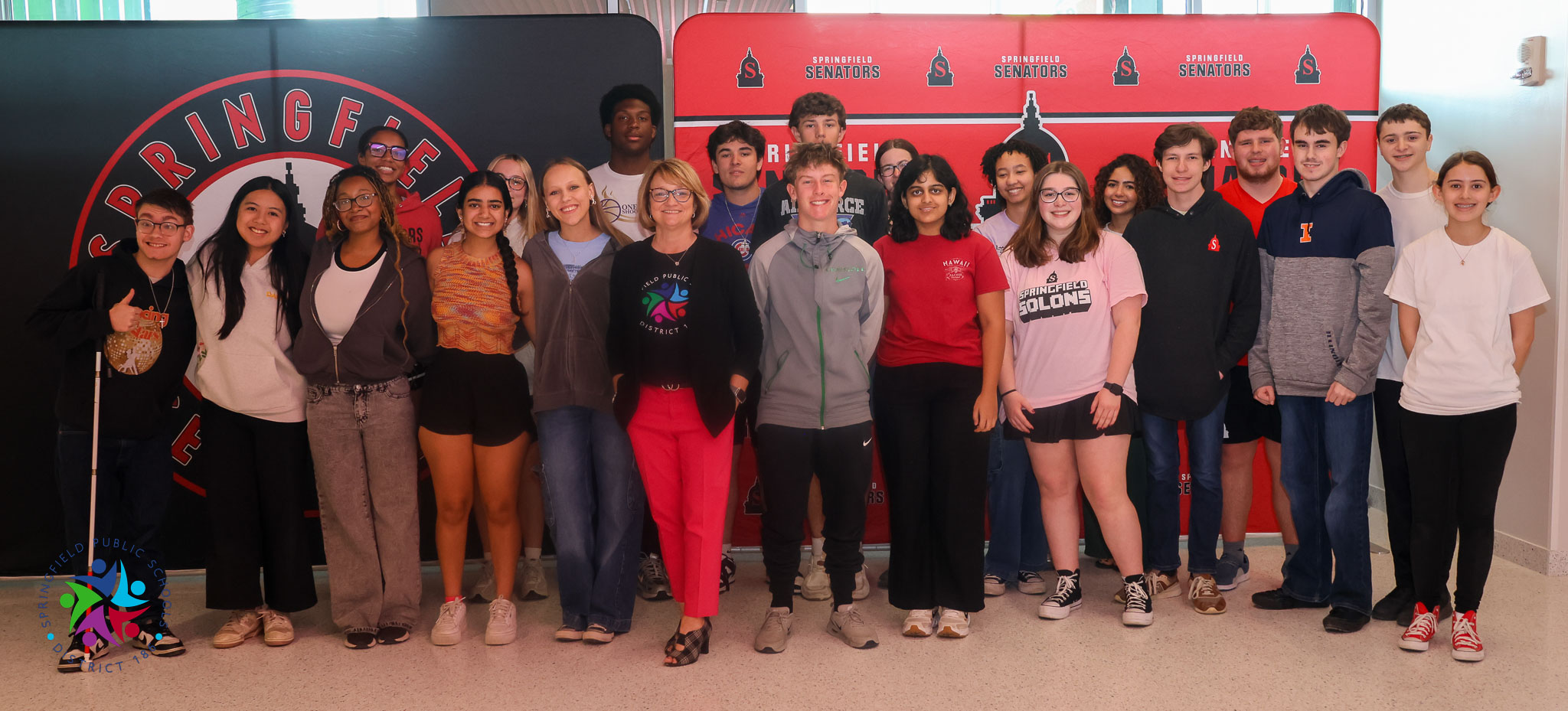 A group of people stands in front of a wall with a red sign reading "PRINCES".