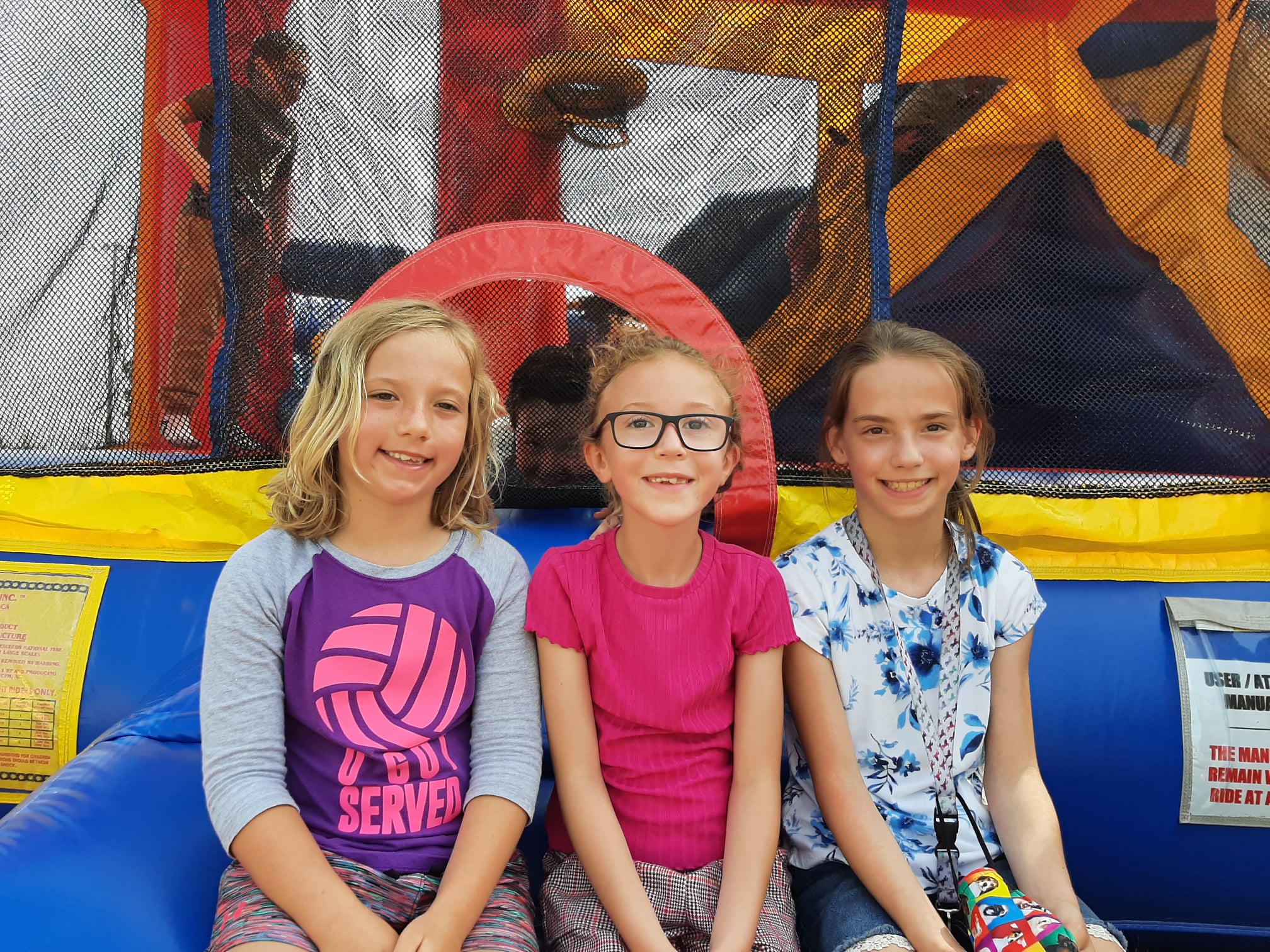 Girls sitting on a bounce house.