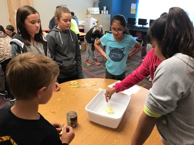 Group of students watching an Apple Raft in a bucket