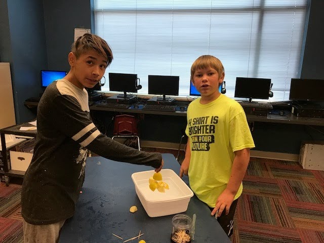 2 students posing for picture with Apple Raft