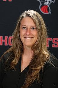 headshot of Carrie in front of Hornets backdrop, long brown hair with black blouse