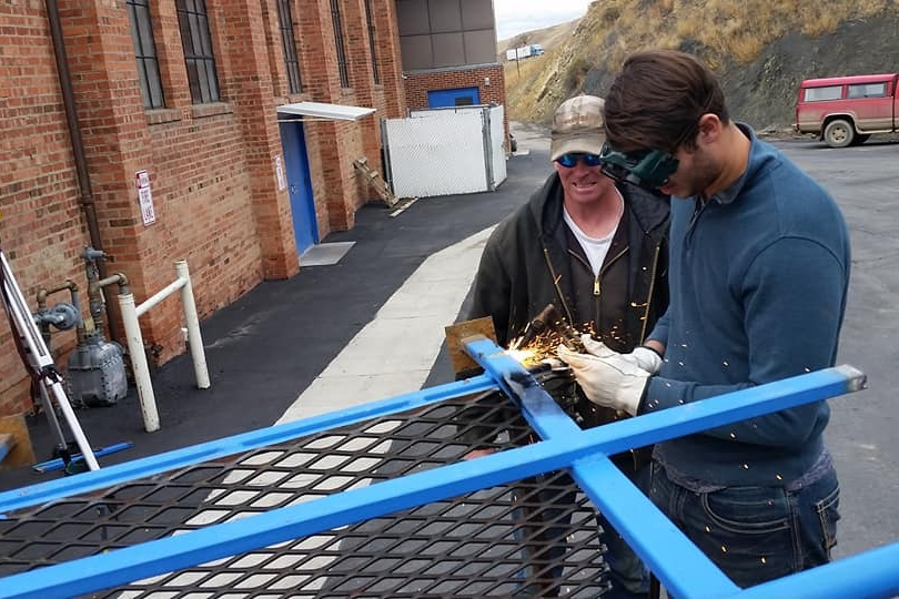 Two students welding metal