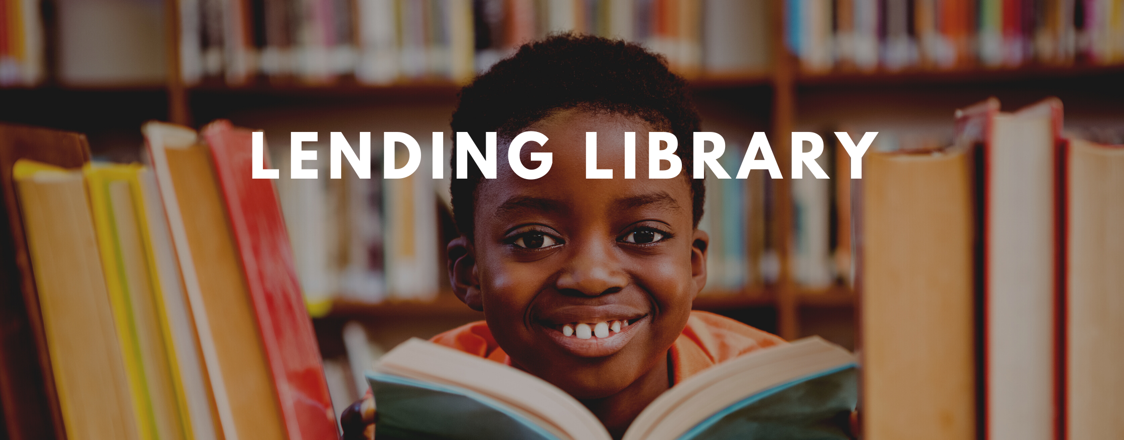 Boy with open book in front of library shelves. Header reads "Lending Library."