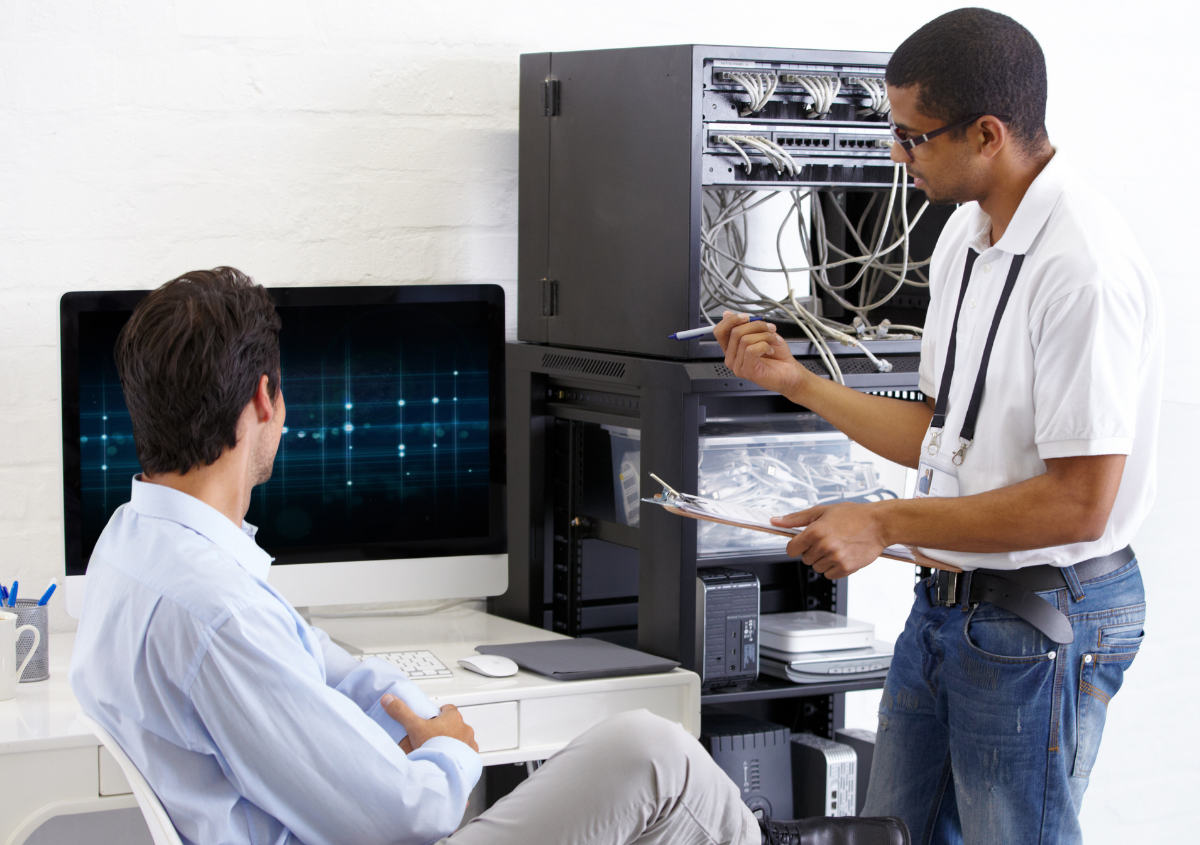 Two people working on IT equipment