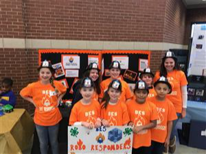 Kids in orange t-shirts and firefighters hats