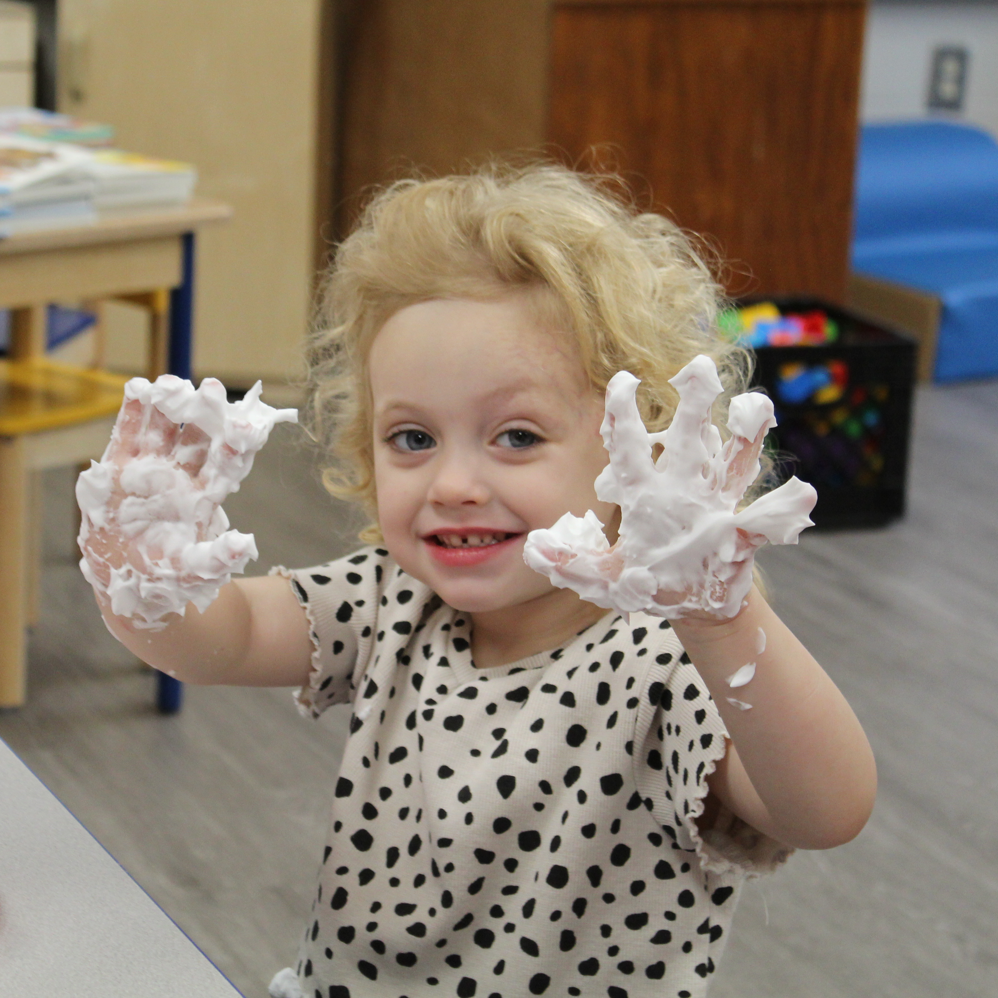 a toddler with foam covered hands