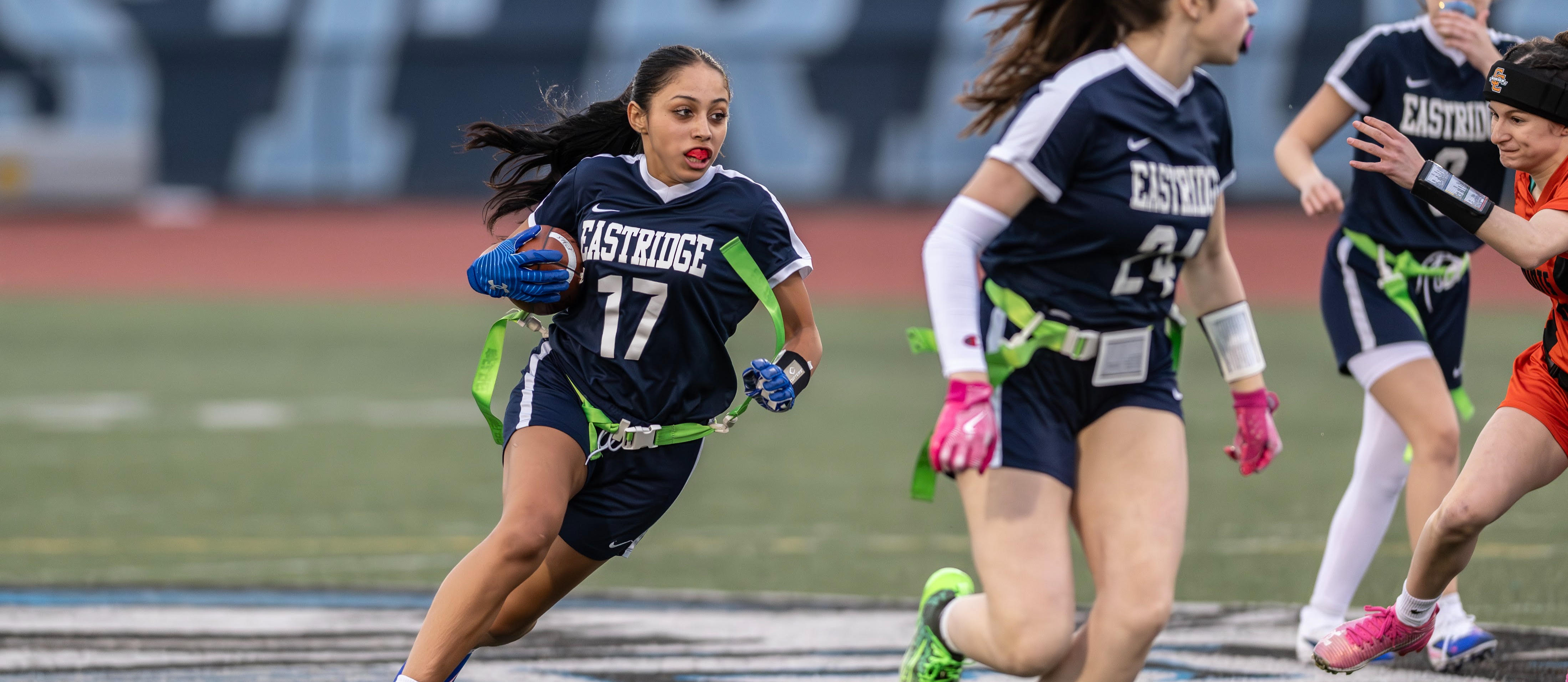 flag football player runs down the field with ball