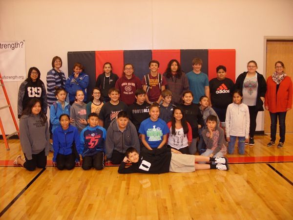group photo of students and teachers in a gym