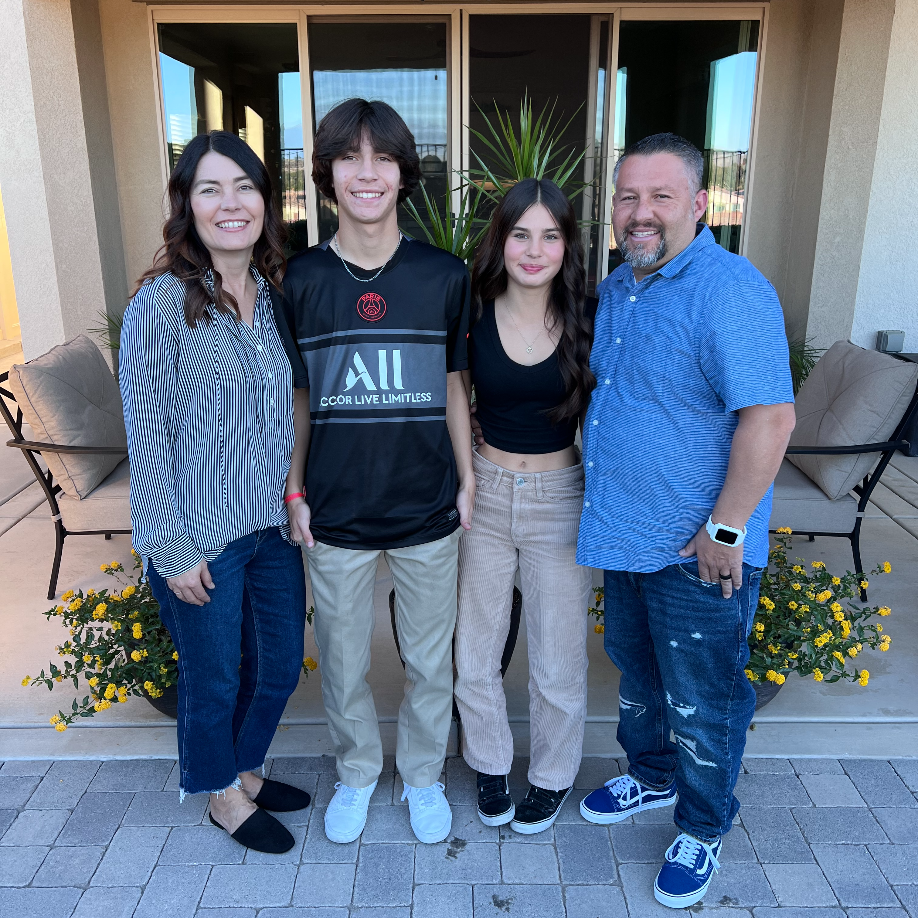 Mrs. Chavez in sunglasses in front of the ocean, smiling with her family