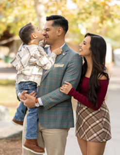 mrs. rodriguez her husband and son standing with trees in background