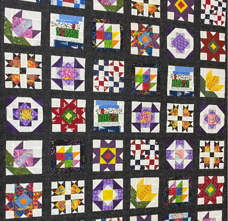 Quilt with rows of houses out of multiple colorful fabrics