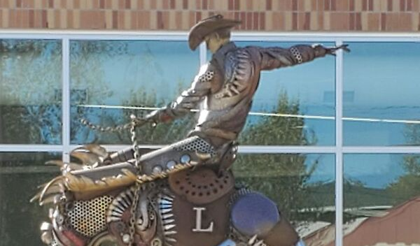 bronze statue of a cowboy riding a bronco