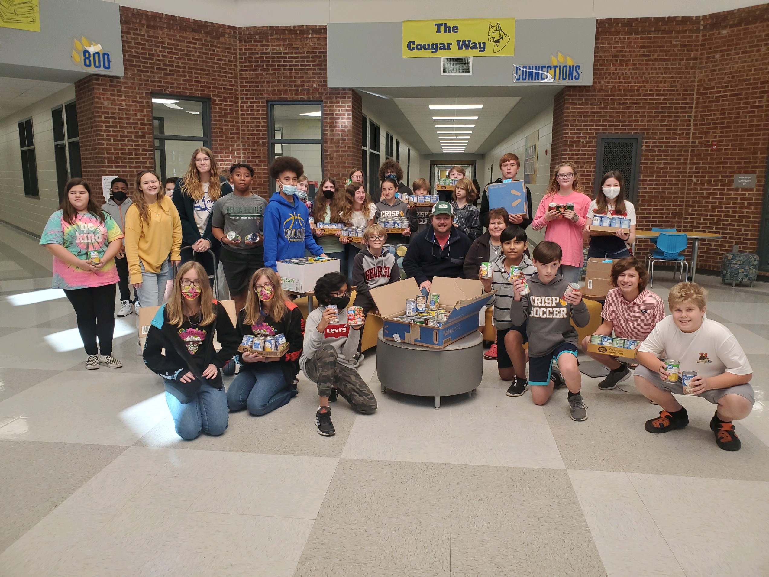 Students with cans of food to donate 
