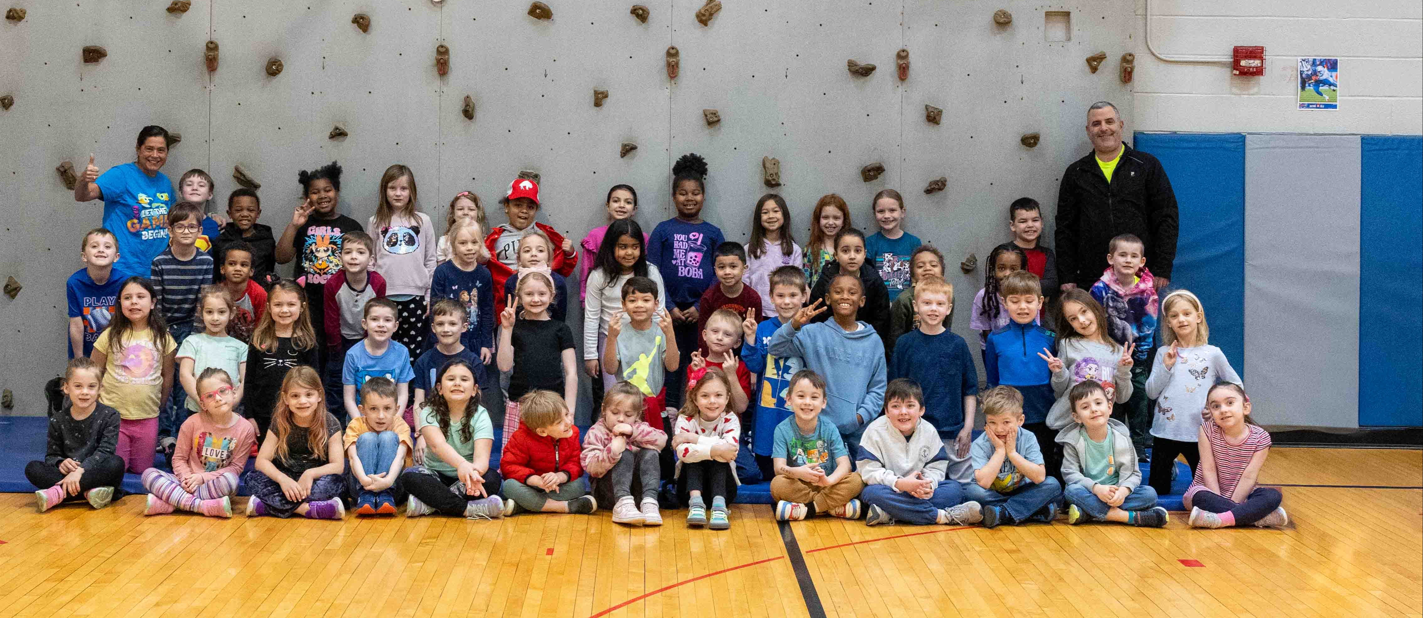 students in the gymnasium smile for a photo