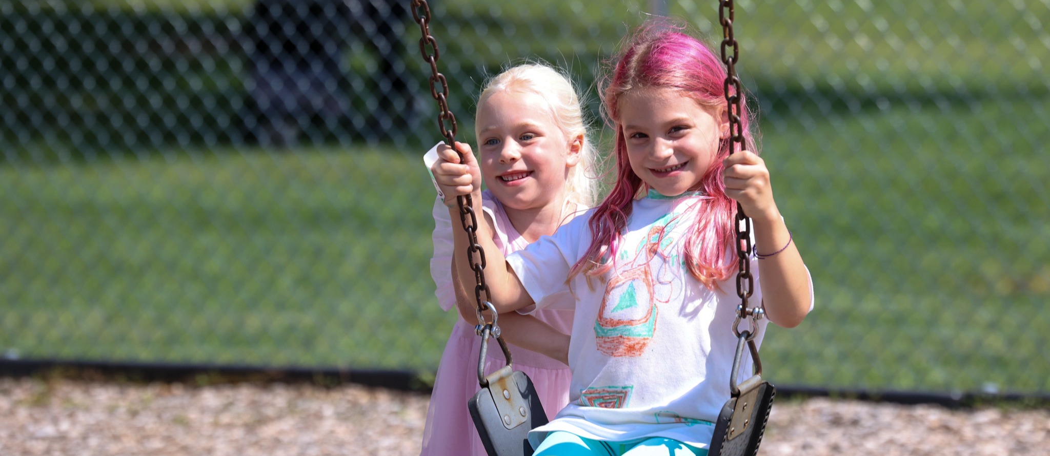 students smile on swing set