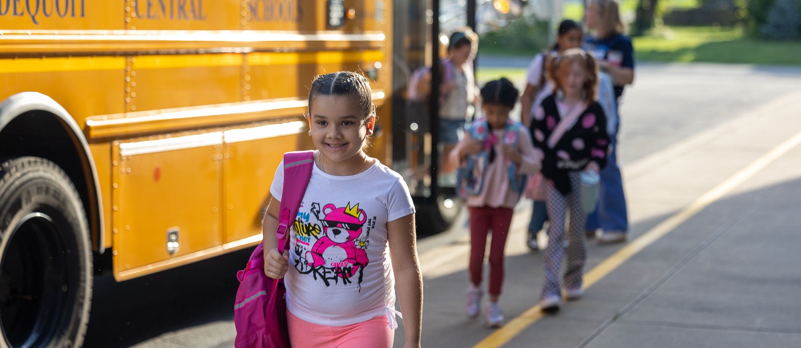student smiles walking into school