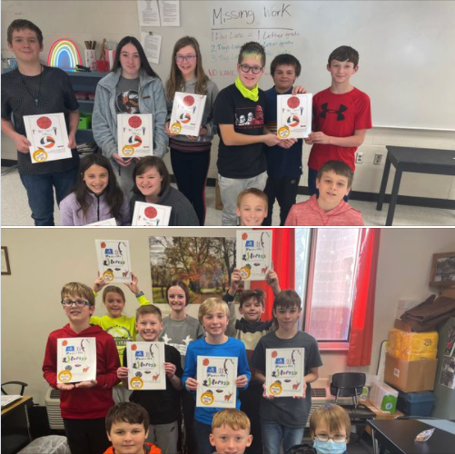 students holding self-published books in their classroom