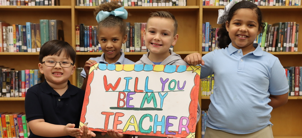 Students holding "Will you be my teacher"