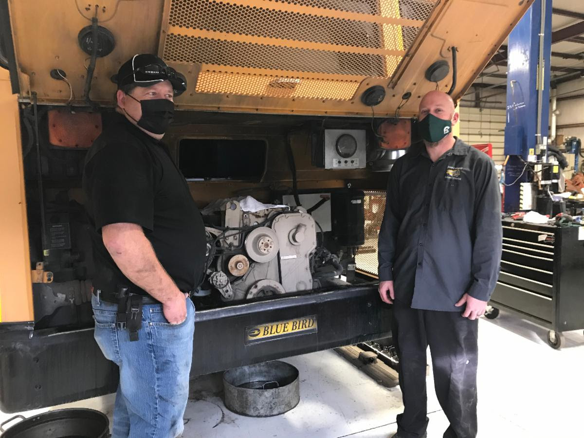 Staff checking a bus engine